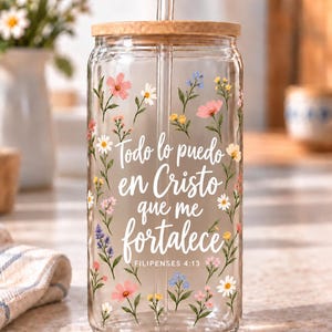 Digital mockup of a clear glass cup showing Spanish Philippians 4:13 lettering surrounded by pink, white and lavender wildflowers. Bamboo lid shown.