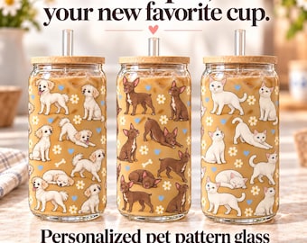 May include: Three clear glass tumblers with bamboo lids and glass straws, each filled with iced coffee. The glasses feature patterns of small white dogs, brown dogs, and white cats, interspersed with white daisies and blue hearts.