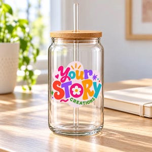 Glass cup with the Your Story Creations logo as a design example, bamboo lid and glass straw.