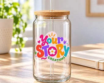 May include: A clear glass tumbler with a bamboo lid and a glass straw. The front features a colourful decal with the text Your Story Creations in a playful, multi-coloured font, accented by a small flower icon and various star shapes.