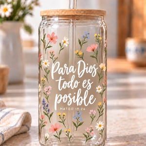 Digital mockup of a clear glass cup showing Para Dios Todo Es Posible and Mateo 19:26 lettering with wildflowers. Bamboo lid shown.