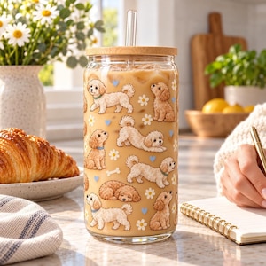 Maltipoo pattern glass cup with bamboo lid and glass straw in an everyday scene.