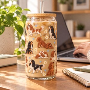 Cavalier King Charles Spaniel pattern glass cup with bamboo lid and glass straw in an everyday scene.