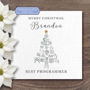 May include: A square white greeting card featuring the text Merry Christmas, Brandon, Best Programmer. A Christmas tree graphic is composed of various computer programming and office icons, topped with a gold star. Three white poinsettia flowers.