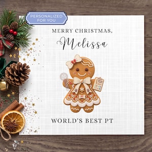 May include: A square greeting card featuring a gingerbread person illustration wearing a bow and holding a clipboard. The text reads Merry Christmas, Melissa and World's Best PT. A blue tag says Personalized For You. The card is decorated with pine, cones, and orange slices.