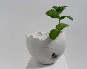 Small white concrete vessel sculpture with stone inlay. Sustainable. Live edge. Outside surface partly shiny & partly matte. Wabi-sabi.