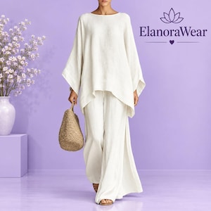May include: An off-white long-sleeved tunic top and matching wide-leg trousers set. The outfit is paired with a textured tan woven handbag. The text ElanoraWear is visible in the upper right corner above a lotus flower icon and a small heart.