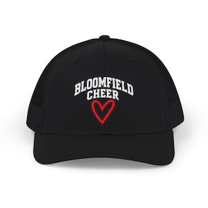 Puede incluir: Una gorra tipo camionero negra con parte trasera de malla y panel frontal sólido. El frente muestra el texto blanco BLOOMFIELD CHEER en una fuente universitaria arqueada, sobre un contorno de corazón rojo centrado en la corona.