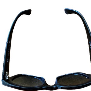 Puede incluir: Gafas de sol negras con un dise&ntilde;o cl&aacute;sico. Las monturas son brillantes y las lentes oscuras. Las patillas de las gafas de sol se curvan hacia atr&aacute;s y tienen el texto "MADE IN ITALY".