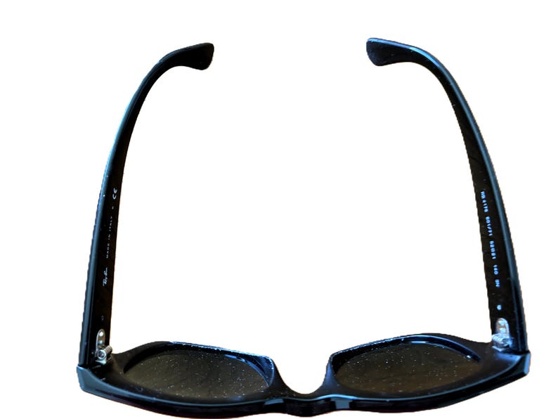 Puede incluir: Gafas de sol negras con un dise&ntilde;o cl&aacute;sico. Las monturas son brillantes y las lentes oscuras. Las patillas de las gafas de sol se curvan hacia atr&aacute;s y tienen el texto "MADE IN ITALY".