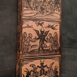 May include: A rectangular wooden plaque with natural bark edges featuring three stacked woodcut-style illustrations in black ink on a light tan background, depicting scenes of horned figures and people interacting in various ritualistic settings.