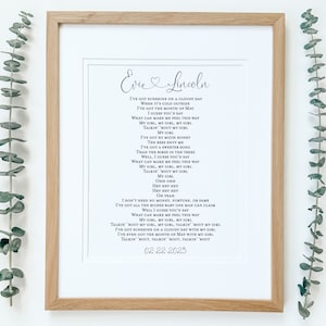 May include: A framed print with a black and white song lyric about love. The lyrics include the names "Evie" and "Lincoln" and the date "02-22-2025".