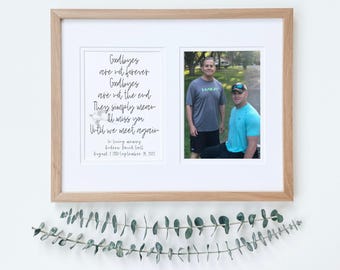 May include: A framed photograph memorial with a black and white quote that reads "Goodbyes are not forever. Goodbyes are not the end. They simply mean I'll miss you until we meet again."  The quote is accompanied by a photo of two men standing outside. The photo is dated 7 August 2017 - 18 September 2017.