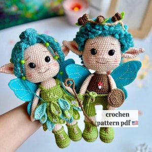 May include: Two crocheted dolls with teal hair, pointed ears, and blue felt wings. One wears a green leaf-patterned dress, the other a brown top with a mushroom detail and green pants. Text on the image reads: crochen pattern pdf.
