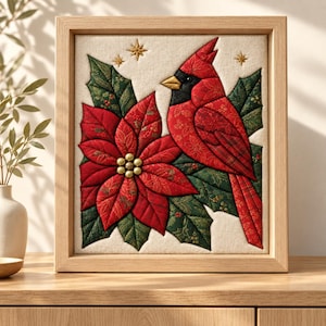 May include: A square framed fabric wall art piece featuring a quilted red cardinal bird perched beside a large red poinsettia flower with green holly leaves. The design includes gold embroidered stars on a cream background within a light wood frame.
