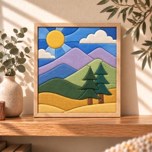 May include: A square framed fabric wall art piece featuring a landscape scene with a yellow sun, white clouds, purple mountains, green hills, and two dark green pine trees. The composition uses layered fabric segments in a vibrant color palette.