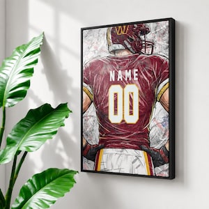 May include: A framed vertical wall art print featuring a stylised illustration of a football player from the back. The player wears a burgundy jersey with the text NAME and the number 00 in white, a burgundy helmet, and black gloves.