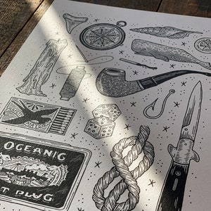 May include: Black and white illustration of nautical themed objects, including a compass, a whale, a pipe, a knife, a rope, dice, a matchbox, a candle, and a tobacco tin that says "Oceanic Out Plug".