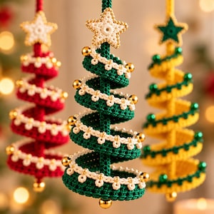 May include: Three hanging spiral Christmas tree ornaments made of crocheted yarn. The trees are red, green, and yellow, each topped with a star and decorated with small white crocheted trim and shiny gold or green spherical beads.