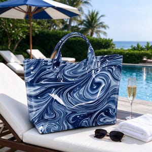 May include: A large tote bag featuring a swirling blue and white marbled pattern with two top handles. The bag has a structured rectangular shape and is made of a smooth material, displaying a continuous abstract design across its entire surface.