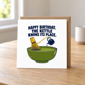 May include: A square greeting card with a white background featuring a green bowl filled with matcha, a bamboo whisk, and a small dark blue kettle pouring liquid. The text reads: HAPPY BIRTHDAY. THE KETTLE KNOWS ITS PLACE. The design uses bold lines and colours.
