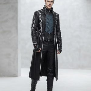Può includere: Un cappotto lungo nero con ricami argentati a forma di ramo sulle maniche, colletto alto e chiusura frontale con bottoni. Sotto, un gilet plissettato blu-grigio, pantaloni neri, guanti senza dita e stivali neri con fibbie laterali.
