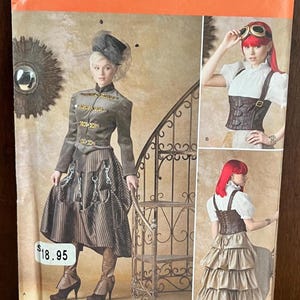 May include: A Simplicity sewing pattern envelope 1558 R5 for sizes 14-22. The front displays two garment variations: a grey jacket with gold accents and a striped skirt, and a brown corset with a white blouse and a tiered metallic skirt.