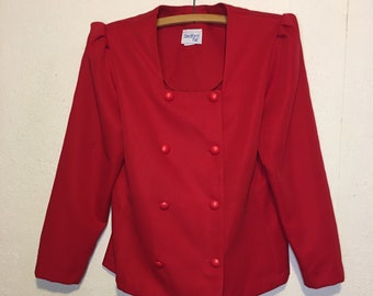 May include: A bright red double-breasted blazer featuring a square neckline, long sleeves with gathered shoulders, and eight matching red fabric-covered buttons. A white label with the text Bedford Fair is visible at the inside of the neckline.