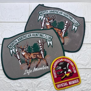 May include: Embroidered patches featuring the "North American Hunting Club" logo. The patches display a deer in a forest setting, with text that reads "Life Member" and "Official Member". The patches have a green border.