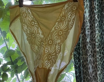 May include: High-waisted pale yellow underwear featuring intricate floral lace panels along the front sides. The garment is constructed with a smooth, solid fabric center panel and finished with delicate scalloped lace trim along the leg openings.