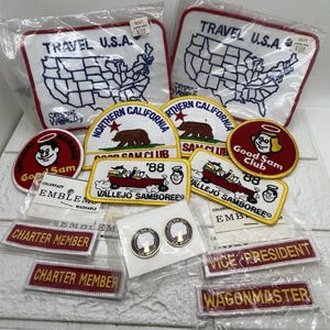 Könnte beinhalten: Eine Sammlung von Vintage-Camping- und Reiseaufnähern und -anstecknadeln. Zu den Aufnähern gehören "Travel U.S.A." mit einer Karte, "Northern California" mit einem Bären und "Good Sam Club". Anstecknadeln zeigen ein Baumdesign. Verschiedene Farben und Formen.