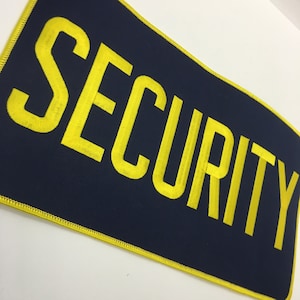 May include: A navy blue patch with yellow embroidered text that reads "SECURITY".