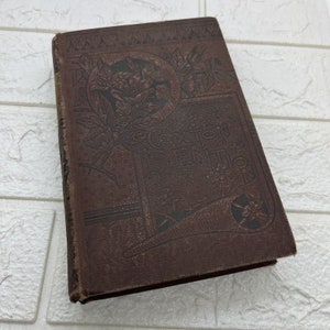 May include: A brown hardcover book titled Caxton Edition with an embossed floral design on the front cover. The cover features dark brown decorative patterns, including leaves and flowers, with the text Caxton Edition centered in a rectangular frame.