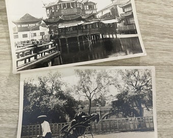 May include: Two black and white photographs. The first shows a traditional Chinese building with a wooden bridge in front of it. The second shows a person riding a rickshaw in front of a bridge.
