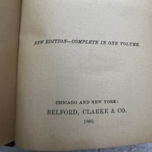 May include: A beige book page featuring black printed text that reads NEW EDITION&mdash;COMPLETE IN ONE VOLUME. Below this, the text reads CHICAGO AND NEW YORK: BELFORD, CLARKE & CO. followed by the year 1885 at the bottom of the page.