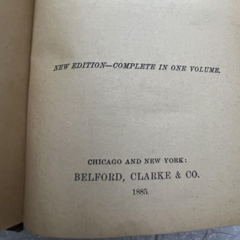 May include: A beige book page featuring black printed text that reads NEW EDITION&mdash;COMPLETE IN ONE VOLUME. Below this, the text reads CHICAGO AND NEW YORK: BELFORD, CLARKE & CO. followed by the year 1885 at the bottom of the page.