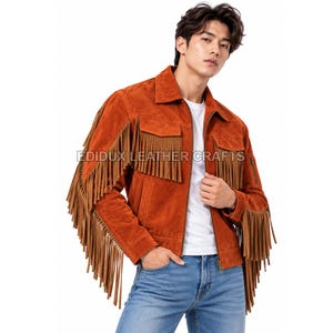 May include: A rust-colored suede jacket featuring long fringe detailing on the sleeves and chest, a classic collar, a front zipper closure, and two chest pockets. The text EDIDUX LEATHER CRAFTS is printed across the center of the jacket.