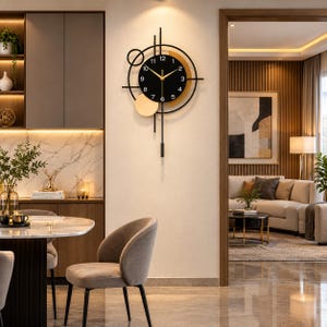 May include: A black wall clock with a circular face, white numerals, and gold hands. The clock features a geometric design with intersecting black lines, a small gold circle, and a vertical pendulum element extending downward from the centre.