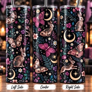 Puede incluir: Tres vasos cilíndricos con pajitas de metal, con un fondo negro decorado con un patrón de conejos marrones, mariposas rosas y marrones, lunas crecientes, estrellas y varios elementos florales morados, rosas y blancos.