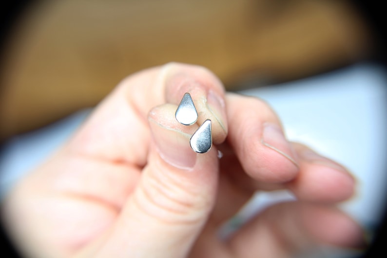 Pu&ograve; includere: Due orecchini a forma di goccia d'acqua in argento.