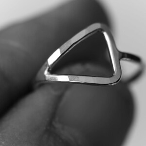 May include: A silver triangle ring with a smooth, polished finish.