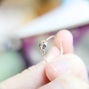 K&ouml;nnte beinhalten: Ein silberner Ring mit einem Marienk&auml;fer-Design. Der Marienk&auml;fer hat schwarze Punkte und ist mit einem gl&auml;nzenden Finish versehen.