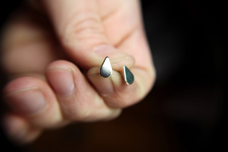 Pu&ograve; includere: Un paio di orecchini d'argento a forma di goccia.