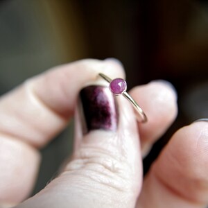 Peut inclure: Une d&eacute;licate bague en argent avec une petite pierre pr&eacute;cieuse ronde rose.