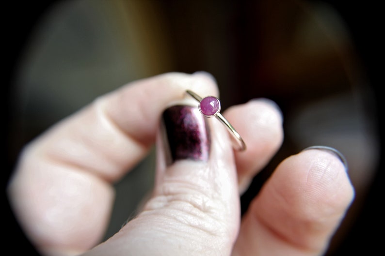 Peut inclure: Une d&eacute;licate bague en argent avec une petite pierre pr&eacute;cieuse ronde rose.