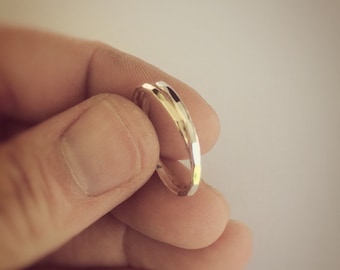 May include: A simple, silver band ring with a hammered finish.