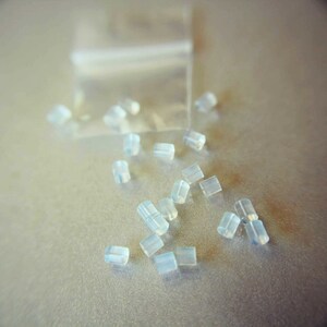 May include: A close-up of a pile of small, clear, plastic earbud tips.