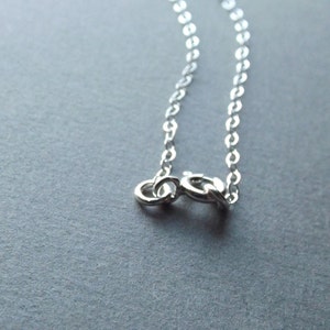 May include: A silver chain necklace with a lobster clasp closure.
