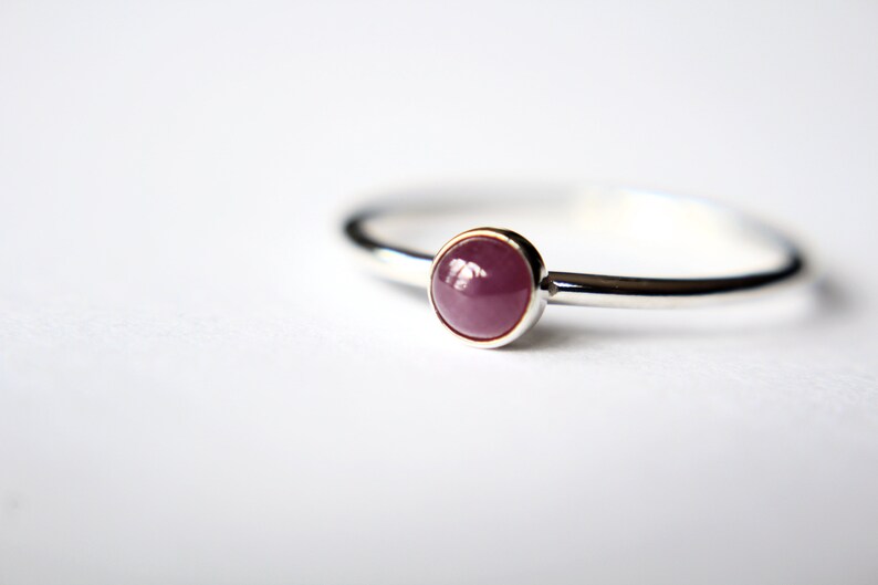 Peut inclure: Une bague en argent avec une pierre pr&eacute;cieuse rose ronde sertie.