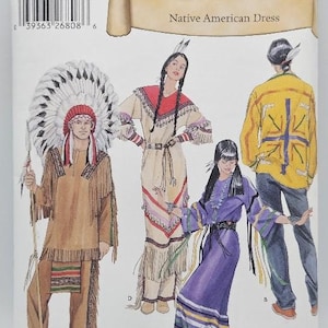 May include: Simplicity Historic pattern 5446 for a Native American dress and outfits. The envelope features illustrations of four individuals wearing tan, purple, and yellow garments with fringe, feathers, and patterned accents.